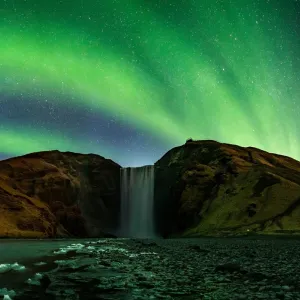 The Northern Lights glowing above Skogafoss waterfall in Iceland. Photo by Snorri Þór.
